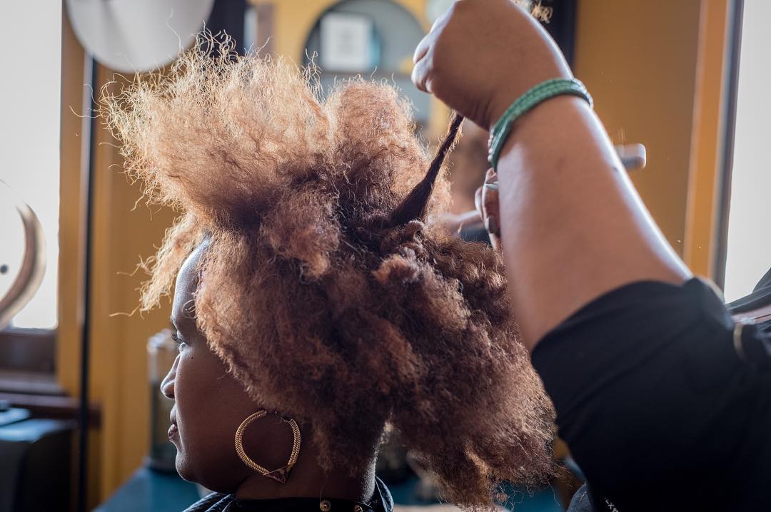 08 maart 2018: Photo and words by @ninarobinsonnyc (Nina Robinson) | Tori Brown, owner of BRE Hair Studio, helps professional women in Louisville, Kentucky find a polished hairstyle uniquely their own. “I think hair is a statement, whatever your ethnicity is. You don't have to be put in a box. I try to encourage my clients to not feel afraid to live out loud," she says. “Every few weeks Ashia Powell, pictured here, comes into Tori’s salon to have her hair detangled, shampooed and conditioned. Then a foaming pomade goes on to add flexibility to her natural coils. Tori wants to strip away the exoticism and mystery often foisted upon African-American women’s hair, along with the stigma. “Hair is hair,” she says. It comes out coarse, medium and fine. It can be straight, curly or kinky. Coils can be tight or loose. Tori’s approach to styling has drawn a loyal following of professional women in Louisville. This photograph is from the #heramerica project Real Womens' Stories Across America produced by Lifetime.”
#PressforProgress #InternationalWomensDay #IWD2018 #WomensHistoryMonth #NatGeoWomen 
